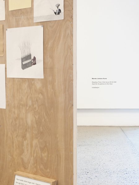 Detail of installation with works on paper arranged on a wall construction. Photography.